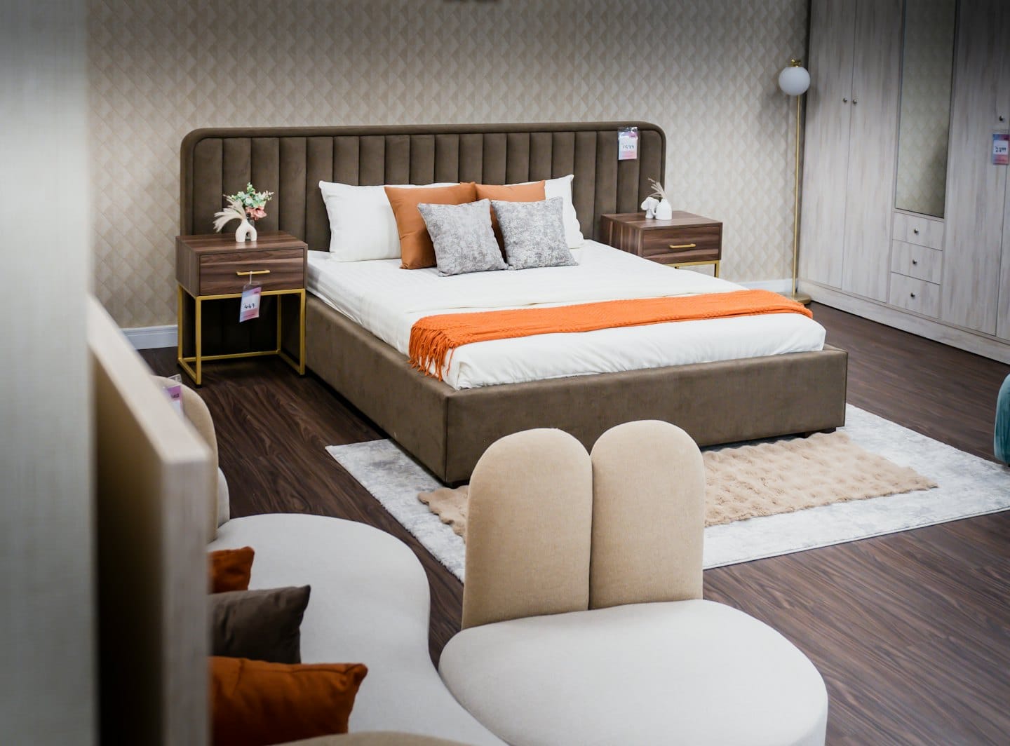 Moderna camera da letto con letto marrone trapuntato e comodini in legno.
